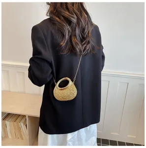 Sparkling acrylic mini evening crossbody bag with gold round handle and chain strap for women.