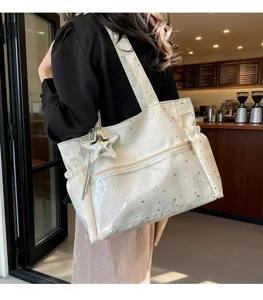Vista dettagliata della borsa tote bianca stellata con la sua bellissima texture e ciondolo.