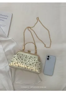 Vue détaillée d'un sac bandoulière coquillage élégant en strass avec chaîne dorée.