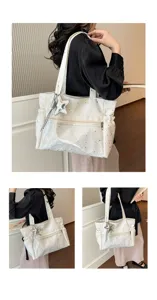 Vista dettagliata della borsa tote bianca con motivo di stelle con una comoda tasca frontale con zip.