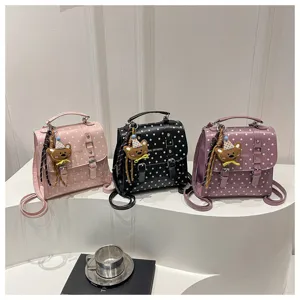 Vista dettagliata del mini zaino a pois in stile dolce e borsa con ciondolo orsetto.