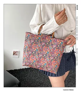 Gros plan détaillé du sac cabas fourre-tout imprimé cachemire avec poignées en bambou.