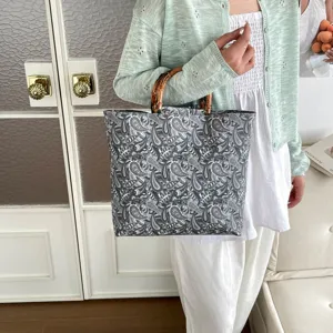 Vista detallada del bolso tote con estampado paisley y elegantes asas de bambú.
