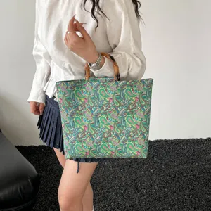 Sac cabas detail mode femme avec impression florale retro et poignees en bambou elegantes.