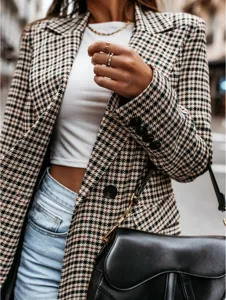 Detail view of women autumn retro houndstooth blazer, showcasing classic pattern and buttons.