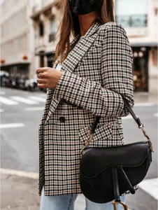 Detailed view of women's vintage houndstooth blazer jacket, stylish autumn outerwear style.