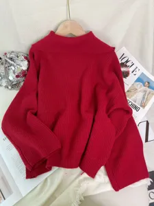 Detailopname van de rode gebreide trui met zachte textuur en een stijlvolle kraag.