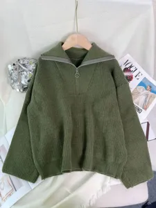 Gedetailleerd overzicht van een effen groene gebreide trui met halve rits en comfortabele pasvorm.