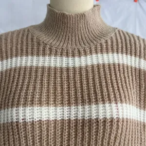 Gros plan sur les détails du pull en tricot rayé à col mi-haut pour femmes chic.