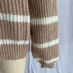 Gros plan sur un pull tricoté pour femme à rayures, texture douce, manches longues décontracté.