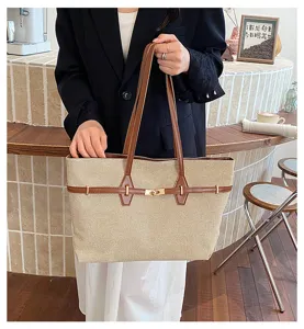Detailed shot of retro canvas tote bag with brown leather trim and metal lock closure for commute.