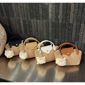 Kleine mini strooien handtas met handvat en pluizige hanger, gedetailleerd overzicht.