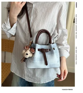 Stylish bucket bag with color-blocked design, top handle and crossbody strap for women.