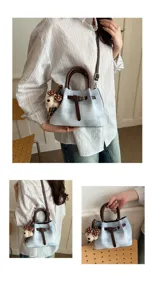 Chic blue plaid bucket bag with brown handle and cute bear charm for daily stylish wear.