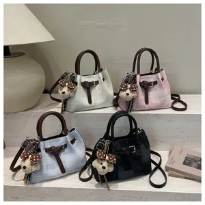Multi-color bucket handbags display scene on steps with cute bear charms and chic details.