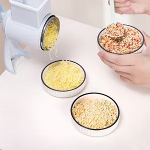 Detail view of the manual rotary cheese grater and nut grinder working on a kitchen table.