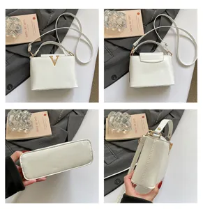 Sac à bandoulière blanc minimaliste avec logo V doré, poignée et sangle réglable.