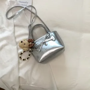 Borsa a mano mini metallizzata argento alla moda con fiocco e simpatico ciondolo orsetto
