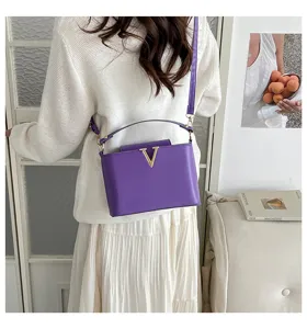 Sac à bandoulière minimaliste violet avec déco V en métal, élégant sac à main femme détail.