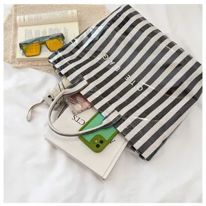 Detail view of a stylish black and white striped tote bag, spacious casual shoulder handbag.