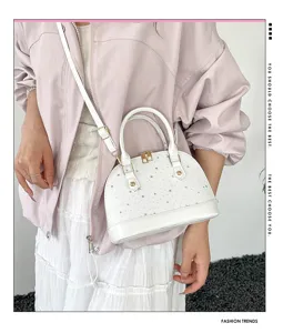 Détail du sac à main dôme blanc avec motif d'étoiles fines et accessoires métalliques.