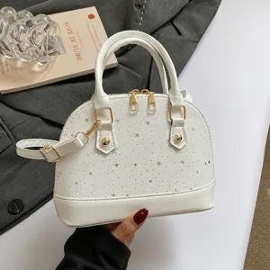 Détail de sac à main dôme blanc avec motif étoilé gaufré et quincaillerie dorée.