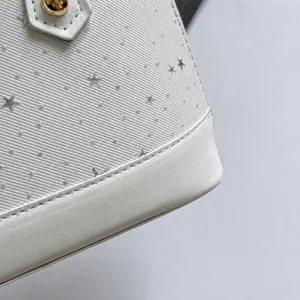 Vue détaillée du sac à main minimaliste pour femme, tissu texturé blanc et étoiles.