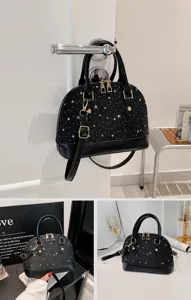 Vue détaillée du sac à main noir avec motif étoiles, sac bandoulière élégant et chic.