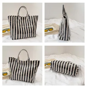 Black and white striped canvas tote bag detail view showing sturdy double handles and texture.