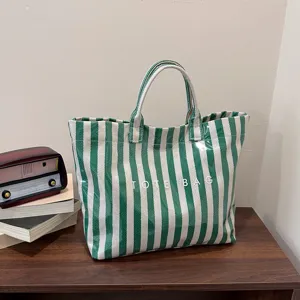 Green and white striped transparent tote bag detail shot showing high capacity fabric.