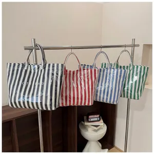 Multi-color striped tote bags hanging on rack showing various color options and details.