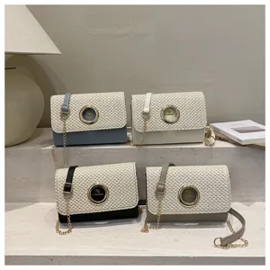 Sac bandoulière tissé avec fermeture à anneau métallique rond en quatre coloris élégants.