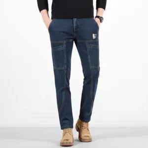 Detailed view of men's slim fit straight denim jeans featuring multi-pocket utility workwear.