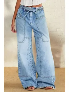 Detail shot of women's light wash wide leg denim jeans featuring a drawstring waist and pockets.