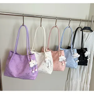 Close-up of stylish Korean star pattern shoulder tote bags with cute plush cloud pendants.