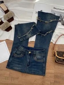 Detail view of stylish womens high-waisted flared denim pants with patchwork frayed edges.