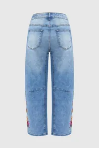 Vista trasera detallada de jeans azul claro con bordado floral colorido y corte ancho.