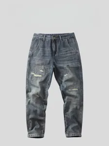 Dettaglio di jeans strappati con lavaggio vintage, sfumature e tagli alla moda.