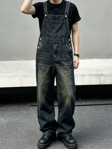 Detailed view of loose streetwear denim overalls, featuring dark vintage wash and multi-pocket.