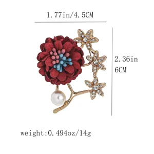 Gros plan détaillé de l'élégante broche fleur en tissu rouge avec des strass et perle.