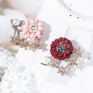 Vue détaillée d'une broche élégante en tissu floral avec perles et strass scintillants.