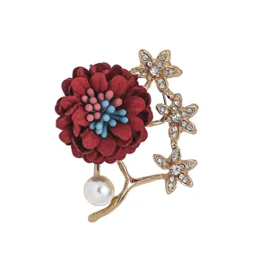 Détail de broche fleur en tissu strass, avec branches en alliage doré et perle.