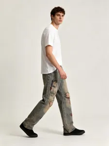 Jean homme destroy imprimé graffiti coupe droite loose streetwear style vue détail mode.