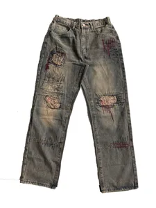 Jean en denim délavé vintage avec détails de fils graffiti tendance et coupe décontractée.