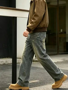 Detailed view of men's vintage distressed loose straight fit denim jeans with washed effect.