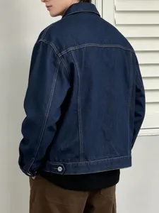 Dettaglio giacca in denim lavato da uomo, con colletto classico e cuciture a contrasto.