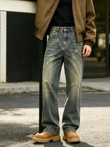 Detail view of distressed loose straight-leg denim jeans, American vintage wash effect, casual style.