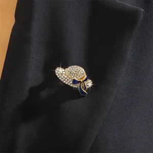 Close-up of crystal hat brooch with blue bow, sparkling rhinestone detail for suit decor.