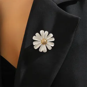 Close-up detail of white enamel daisy brooch, elegant floral lapel pin for blazer dec.