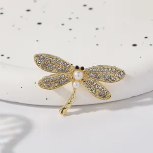 Exquisite rhinestone dragonfly brooch detail, gold-tone metal crystal lapel pin accessory.